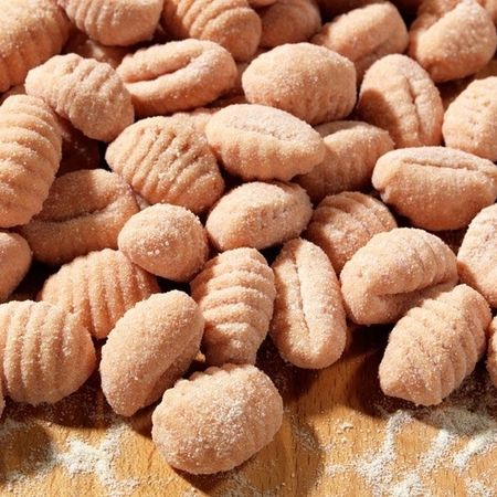 Rote Gnocchi angerichtet auf einem leicht bemehlten Holzbrett